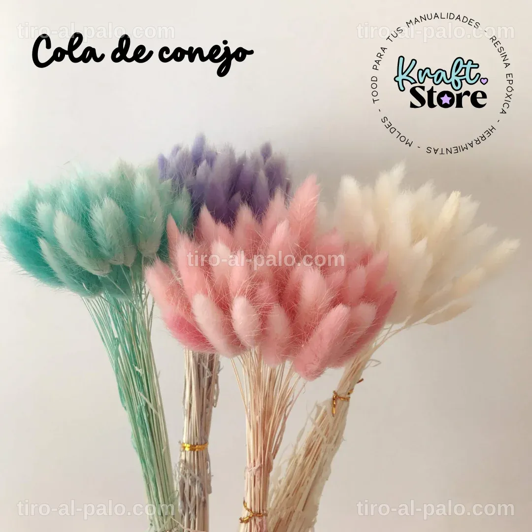 Colección de colas de conejo junto a flores secas en una mesa de trabajo.