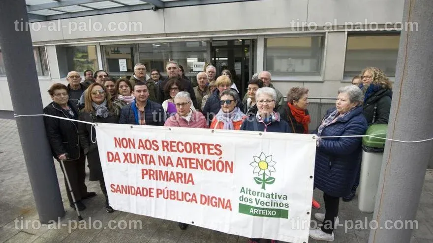 Protesta de Alternativa dos Veciños frente a un edificio, con pancartas y asistentes.