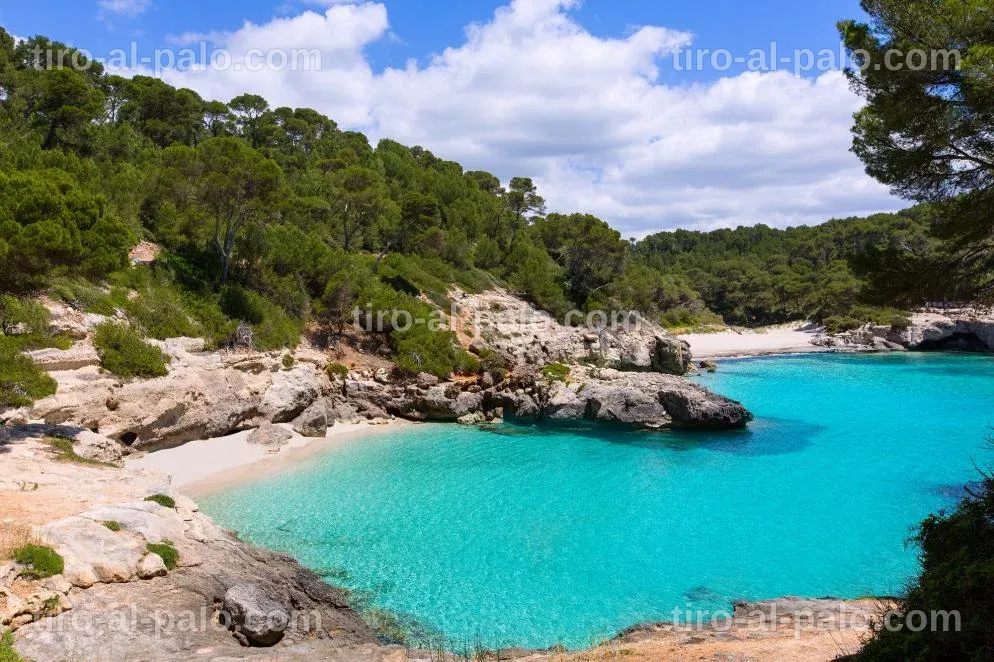 Cala serena con aguas transparentes y formaciones rocosas, perfecta para relajarse.