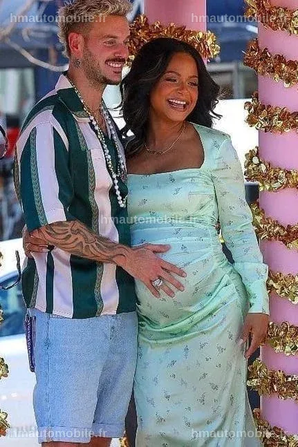 Christina Milian souriante, vêtue d'une tenue élégante.