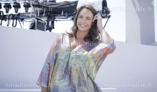 Julia Vignali posant avec une main sur son ventre, rayonnante de bonheur.