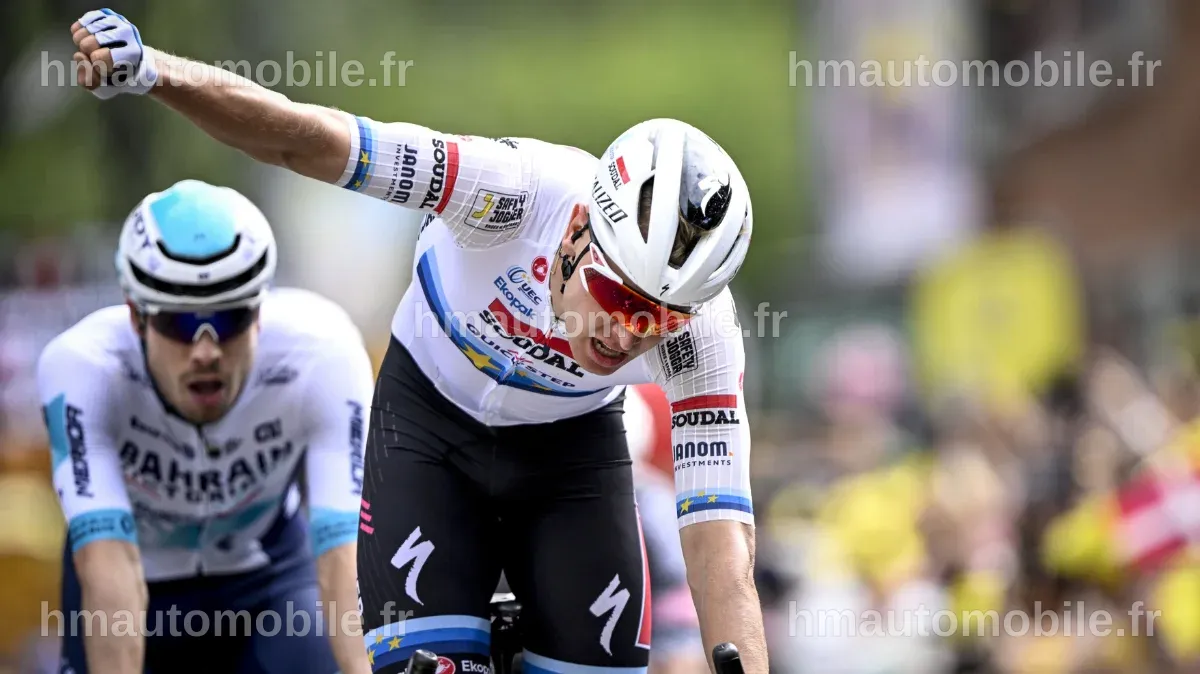 Tim Merlier levant les bras en signe de victoire après avoir gagné la 3e étape.